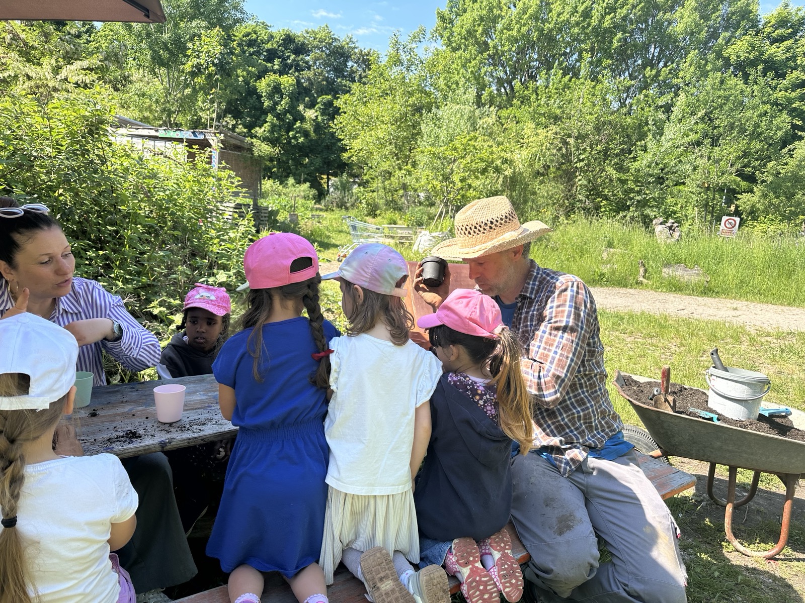 Martin mit einer Kindergruppe am Tisch im Garten